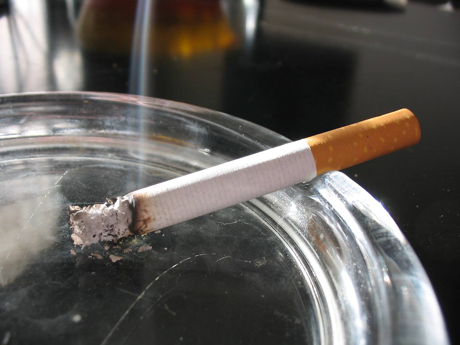 photograph of a cigarette burning in an ashtray