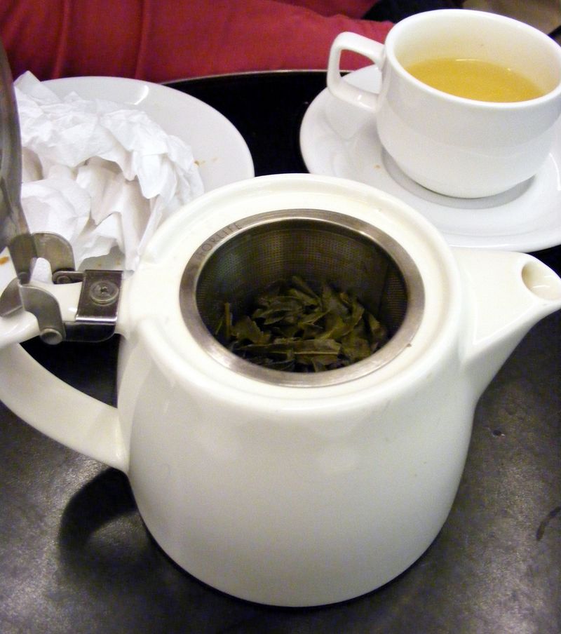 té verde en una tetera con una taza cerca
