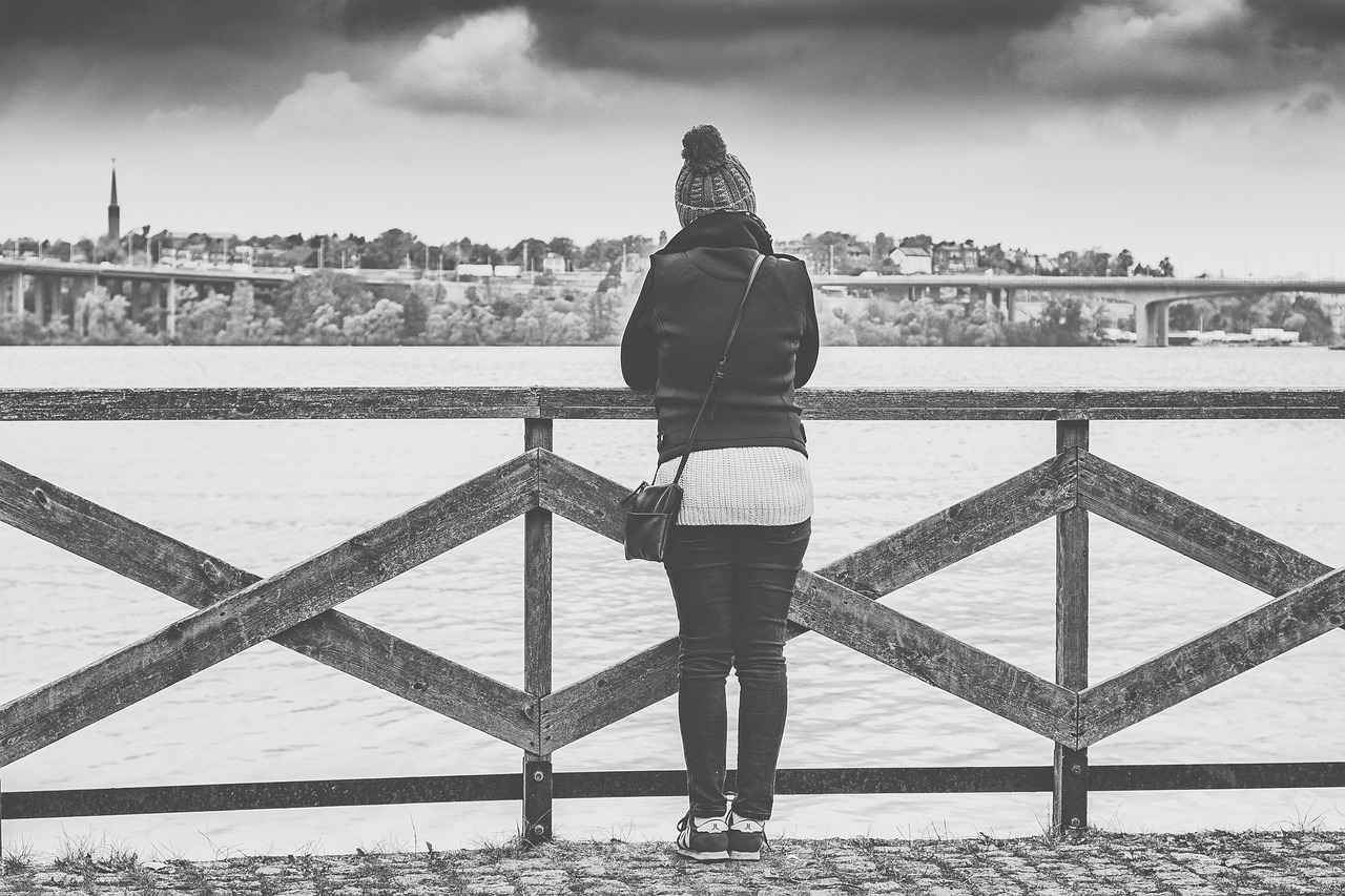 Woman looking out over water (black and white photo)