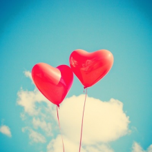 red heart-shaped balloons in the sky