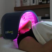 a woman undergoing phototherapy on her face while laying on a bed