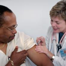 female doctor giving a vaccination to adult male